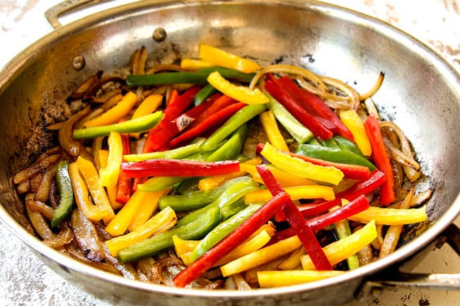 showing how to make Pepper Steak recipe by stir frying red, yellow and green bell peppers in a stainless steel pan