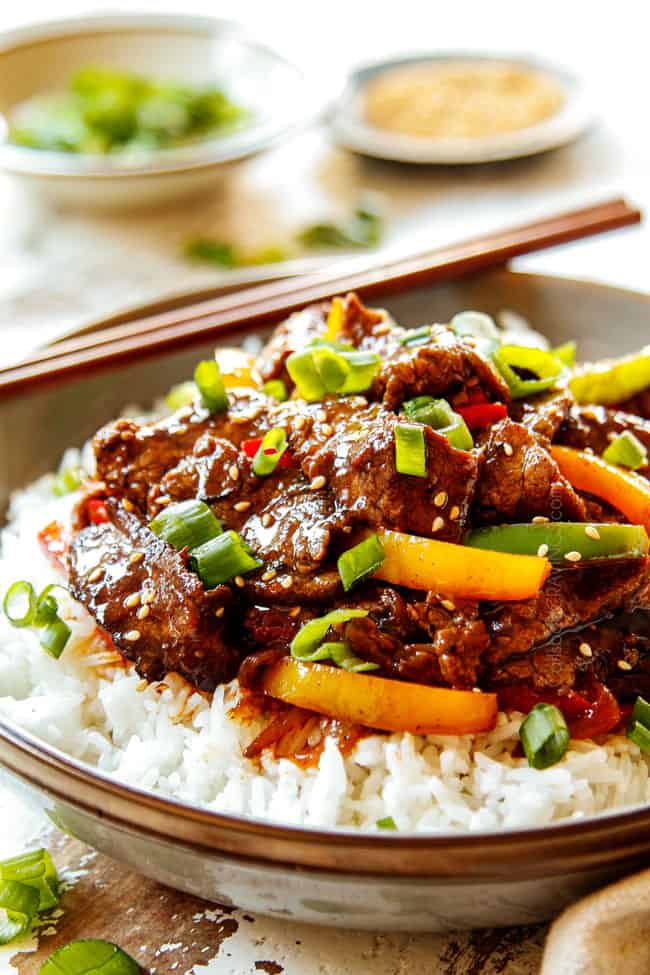 showing how to serve Pepper Steak recipe by adding to a bowl of white rice