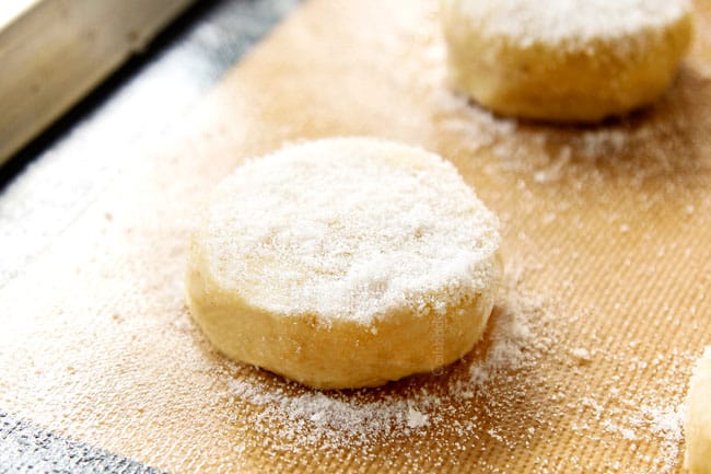 showing how to make Strawberry Shortcake by adding sugar to biscuit rounds on a nonstick mat