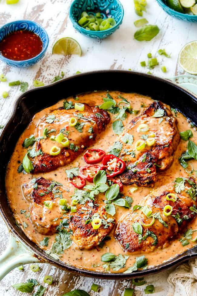 side view of coconut milk chicken in a cast iron skillet showing how creamy it is