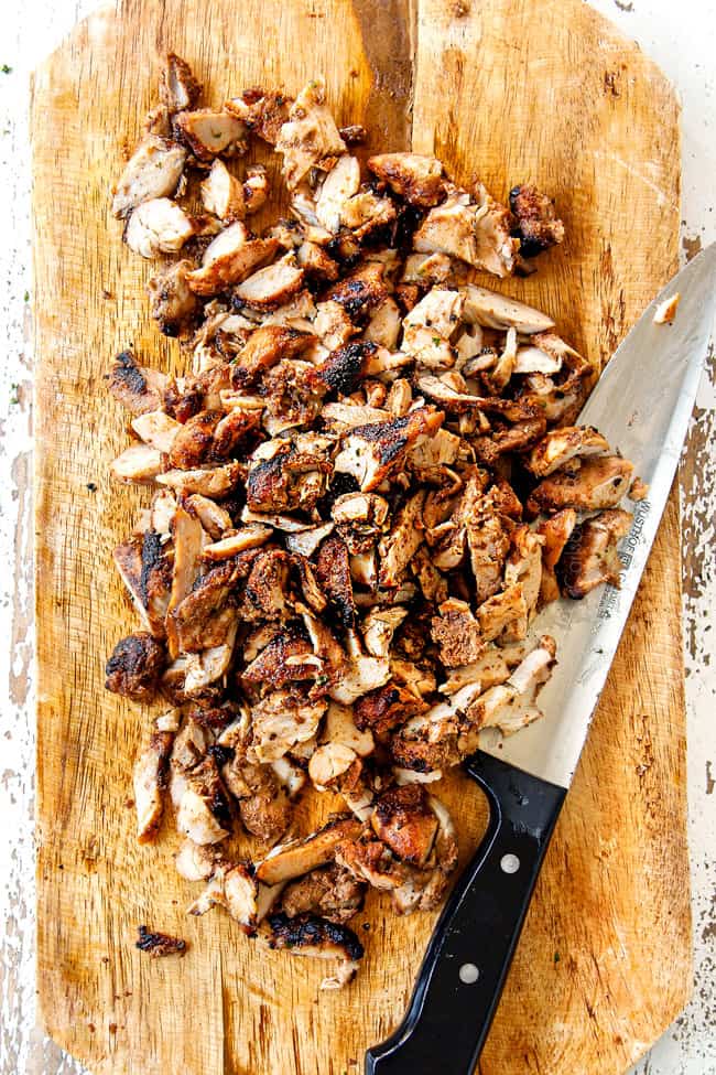 showing how to make doner kebab by thinly slicing meat off of the skewers onto a cutting board