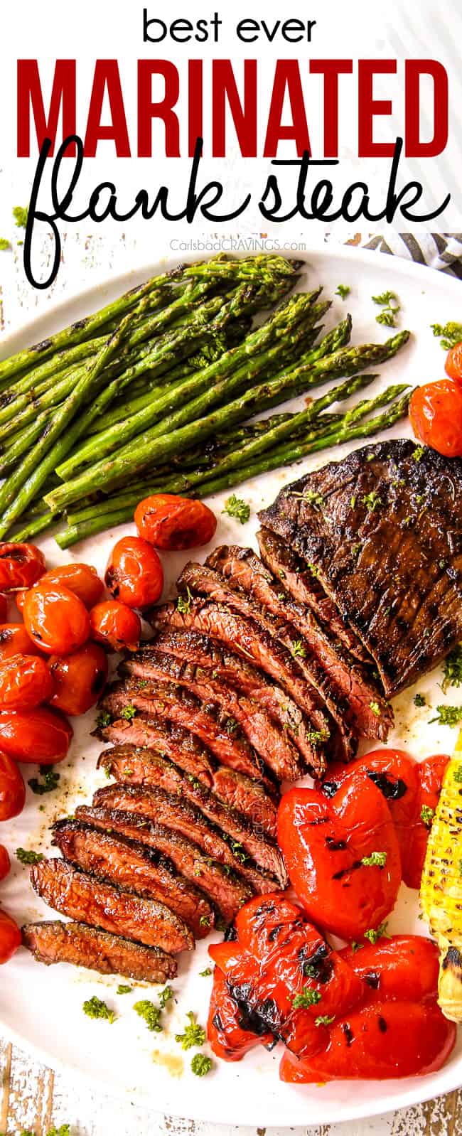 top view of flank steak recipe cut in thin slices on a white platter with grilled corn and asparagus