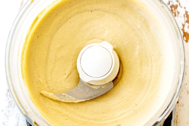 showing how to make hummus recipe by blending hummus in food processor until very smooth