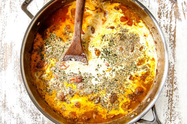 showing how to make spinach pasta by adding chicken broth, heavy cream and herbs to stainless steel skillet