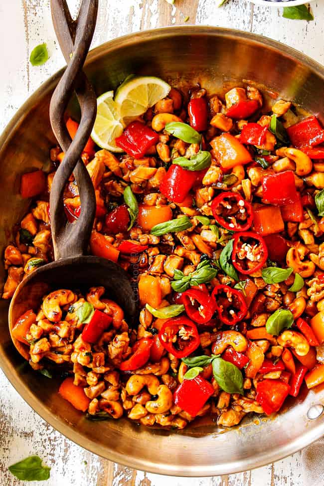 top view of Basil Chicken recipe in a stainless steel skillet showing how to garnish with fresh basil