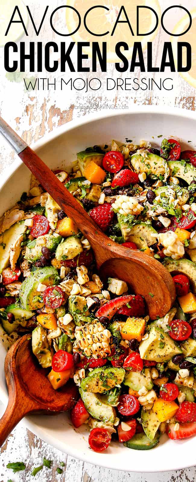 top view showing how to make avocado chicken salad by tossing avocados with corn, black beans and tomatoes in a white bowl
