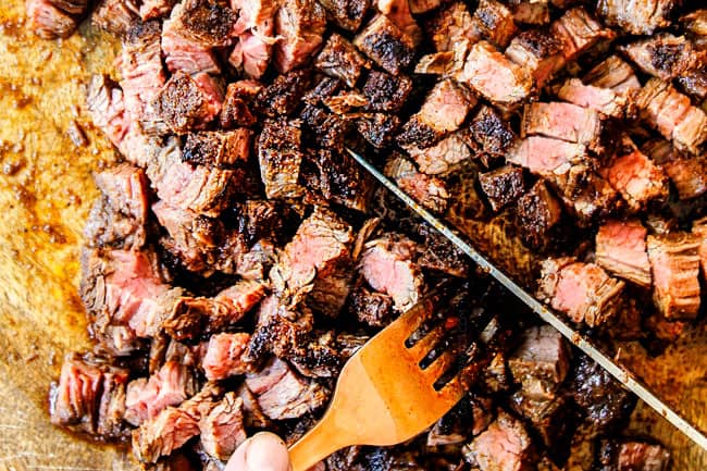 showing how to cut flank steak for steak tacos by cutting it into bite size pieces