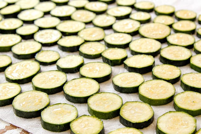 showing how to make zucchini casserole by salting zucchini slices