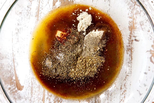 showing how to make pork chop marinade recipe by whisking olive oil, orange juice, balsamic and maple syrup to a glass bowl