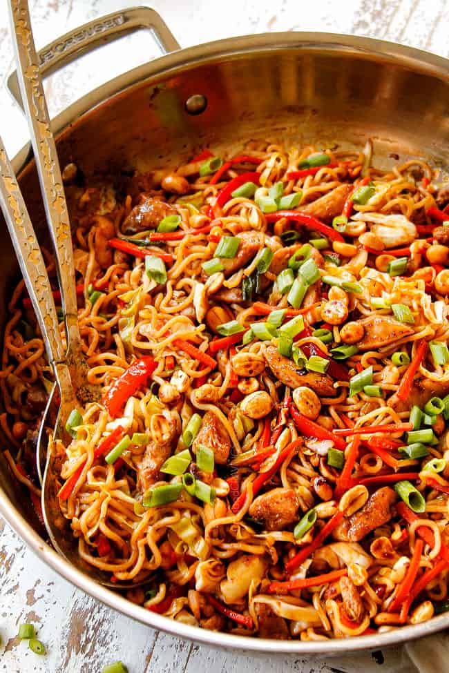 showing how to make chicken yakisoba by tossing yakisoba noodles with yakisoba sauce and green onionsv