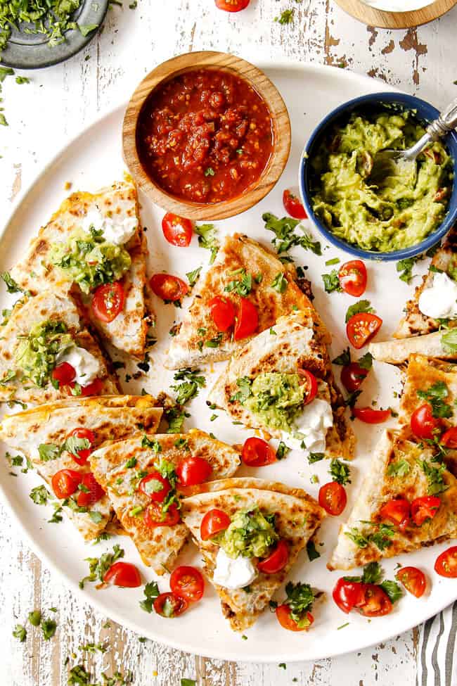 top view of breakfast quesadilla recipe with sour cream, salsa and guacamole