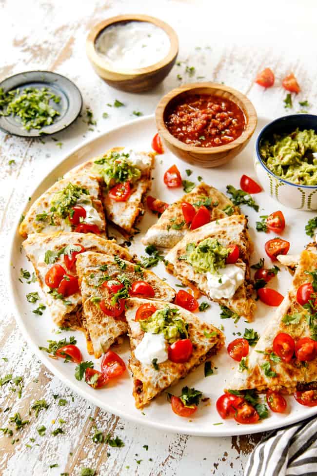 breakfast quesadillas stacked on top of each other with sour cream and guacamole