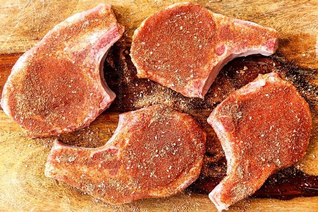 showing how to cook pork chops by seasoning pork chops with a spice rub