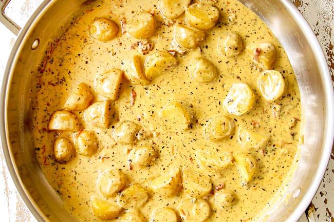 showing how to make creamy Tuscan chicken by adding Parmesan to the sauce