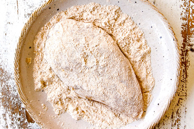 showing how to make creamy Tuscan chicken by dredging a chicke fillets in flour
