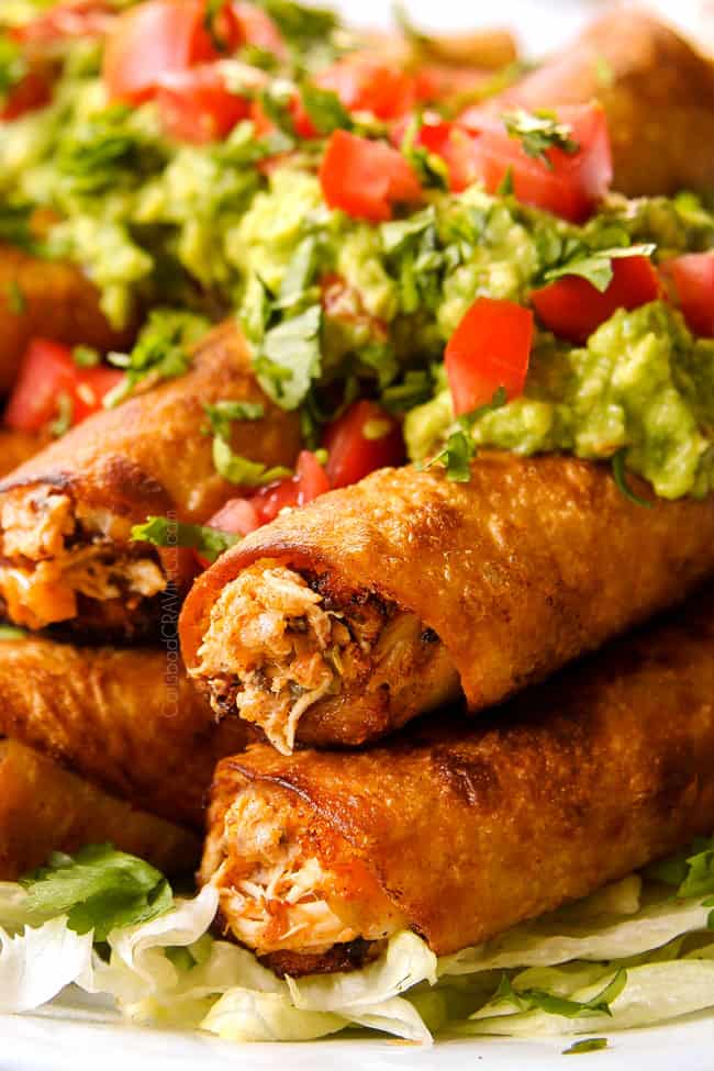 up close of chicken flautas topped with guacamole