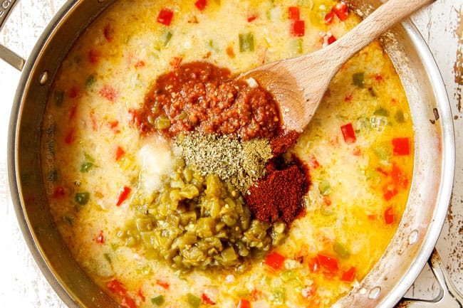 showing how to make King Ranch Casserole by adding chicken broth, salsa and green chilies to the stainless steel pan with bell peppers