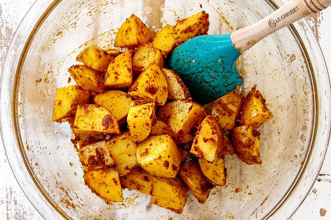 showing how to make steak and potatoes recipe by seasoning potatoes in a glass bowl and string to coat