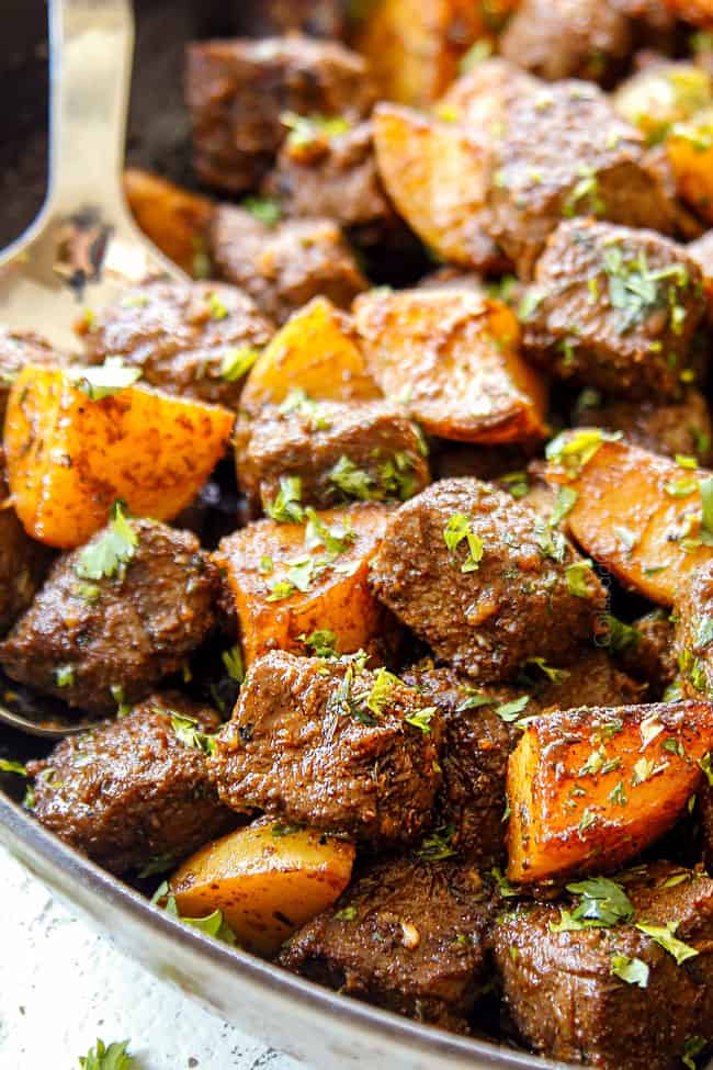 up close of garlic butter steak and potatoes skillet showing how juicy the steak bites are