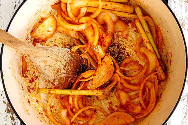 showing how to make Thai Tom Yum Soup by sautéing the lemongrass, onions, galangal, and ginger in a white Dutch oven