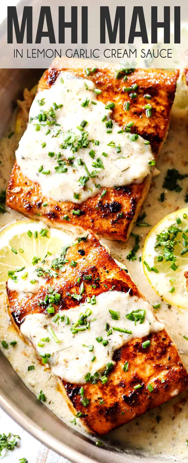 up close view of mahi mahi on a stainless steel skillet with lemon cream sauce