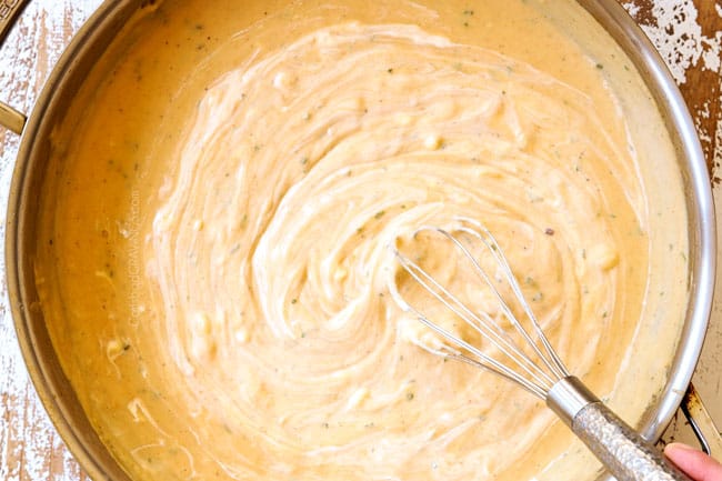 showing how to make chicken broccoli and rice casserole by stirring sour cream into the from scratch sauce without any canned soups