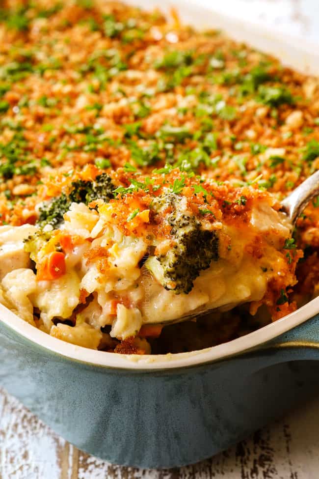 up close of scooping up chicken broccoli and rice casserole showing how cheesy it is
