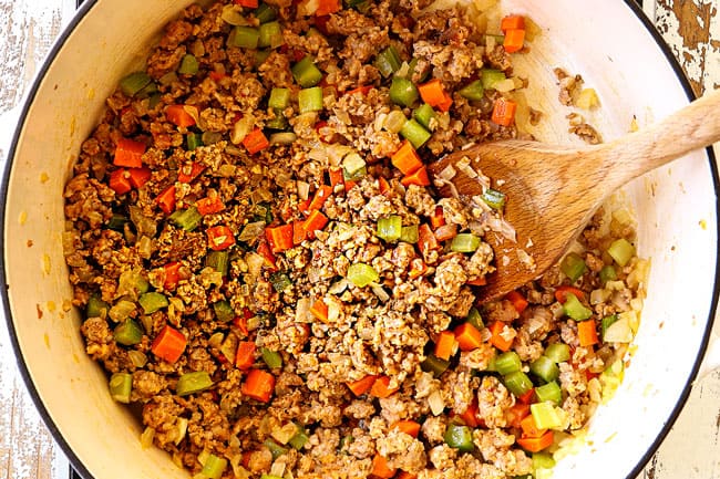 top view showing how to make corn chowder by sautéing carrots, celery and onions in a white Dutch oven