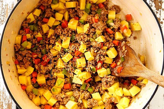top view showing how to make corn chowder recipe by adding potatoes to white soup pot