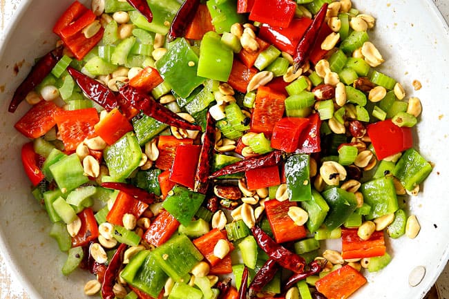 showing how to make kung pao chicken by stir frying bell peppers, celery, onions, garlic and red chilies