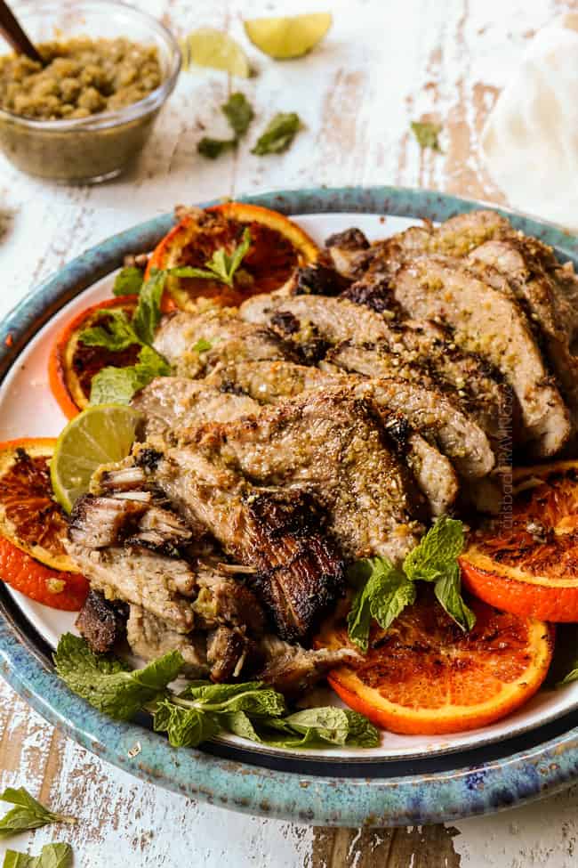 Cuban roast pork (lechon asado) sliced on a white place garnished with orange slices