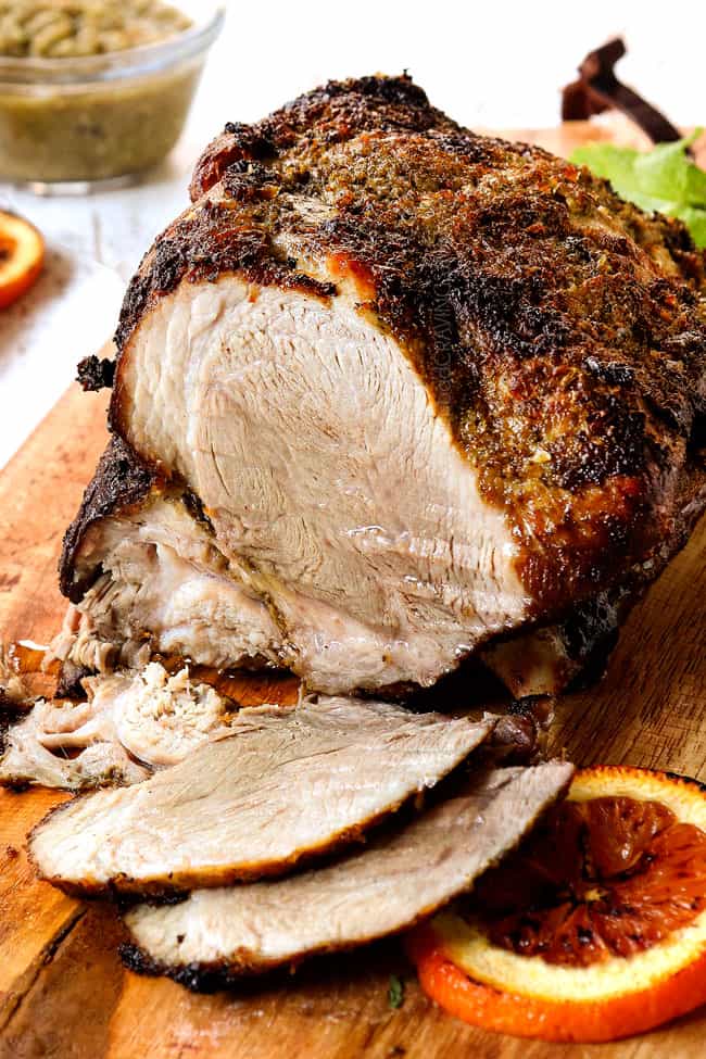 Mojo Cuban Roast Pork (lechon asado) on a cutting board with two slices showing how juicy it is inside
