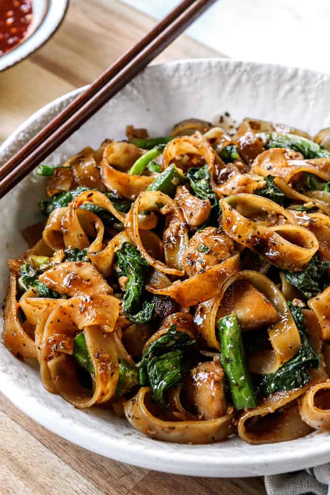 up close of pad see ew in a white bowl with wooden chopstick