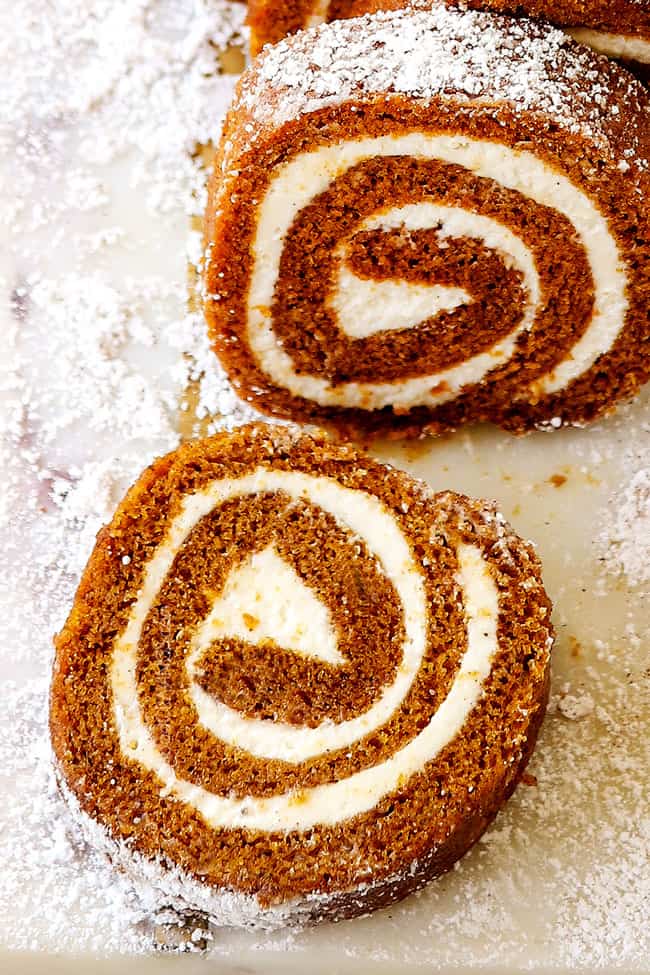 a slice of pumpkin roll on a white cutting board
