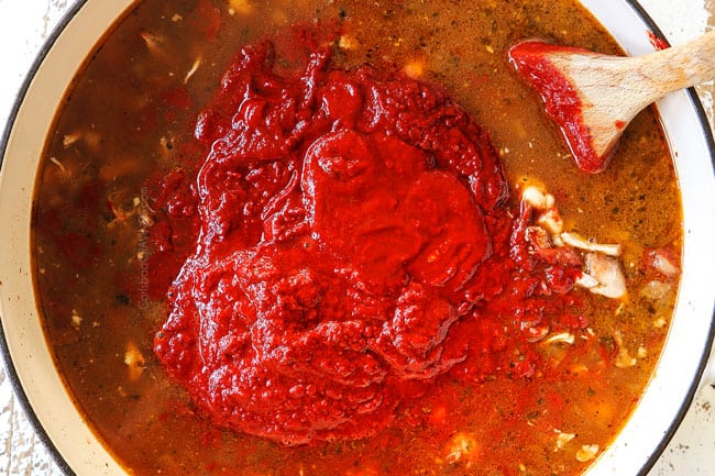 showing how to make pozole by adding chili sauce to stew