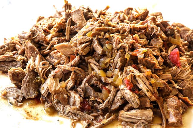 showing how to make pozole by shredding pork on a cutting board