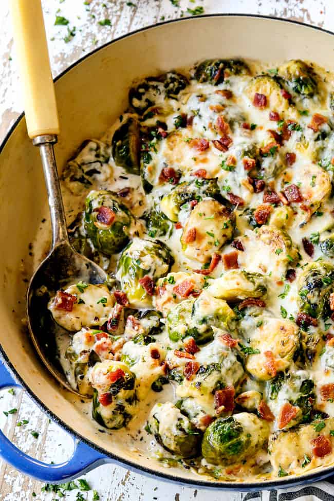 scooping up Brussel sprouts with bacon in blue pan