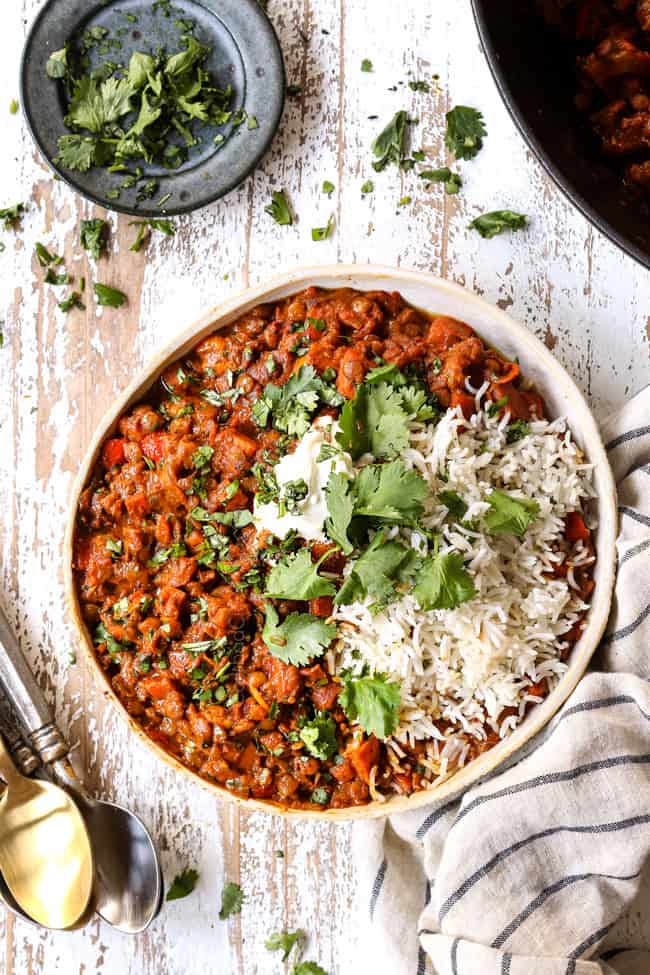 top view of lentil curry in a bowl with white rice and cilantro