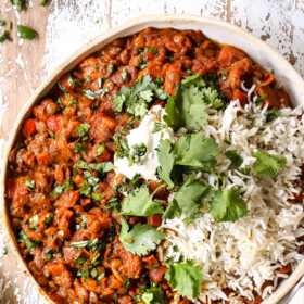 top view of lentil curry in a bowl with white rice and cilantro