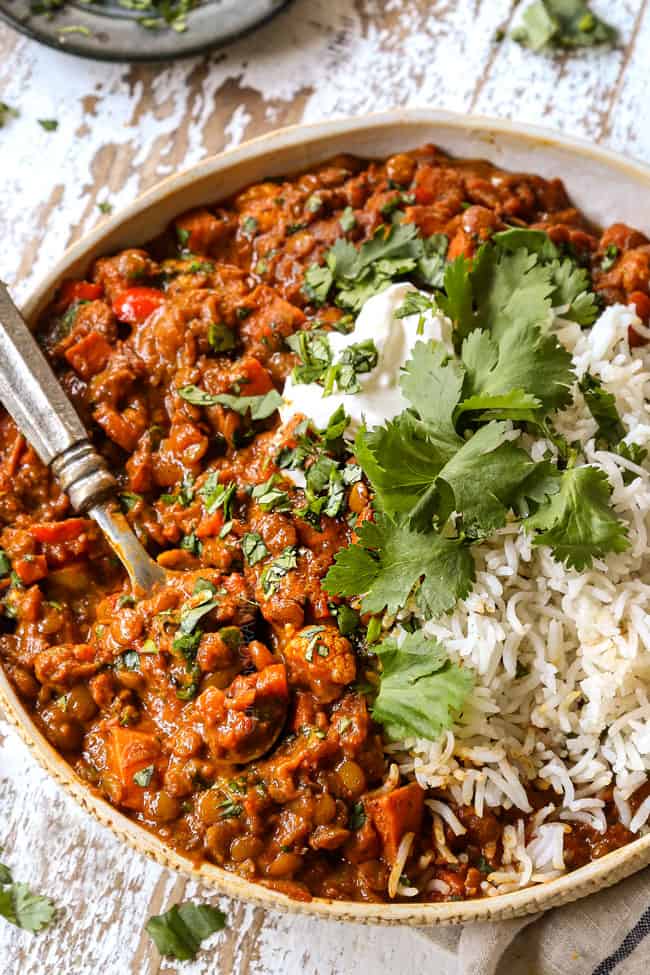 up close of coconut lentil curry in a cream bowl showing how thick and creamy it is