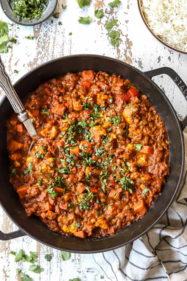 top view of lentil curry in a black pot garnished with fresh cilantro