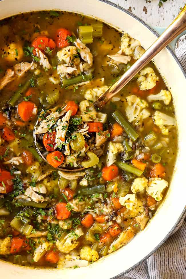 showing how to make turkey soup by garnishing a big pot of soup with parsley