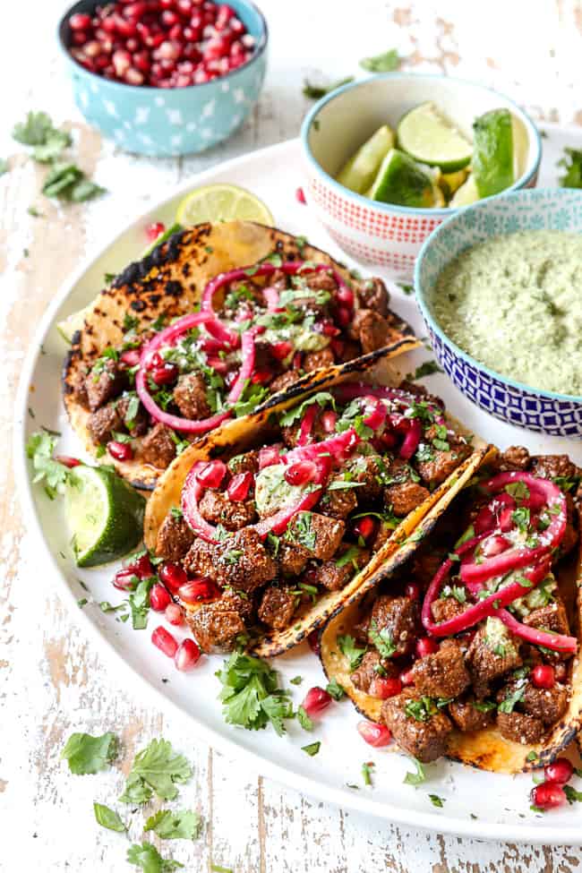 steak tacos lined on a white plate seasoned with steak taco seasoning