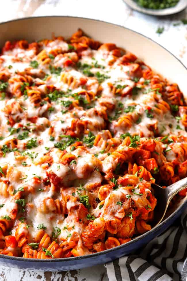 chicken Parmesan pasta smothered in mozzarella cheese and garnished with pars