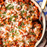 top view of Parmesan Chicken Pasta in a skillet with mozzarella cheese