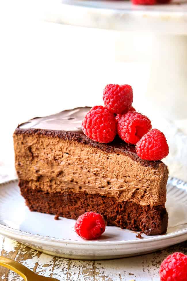 side view of a slice of Chocolate Mousse Cake on a white plate