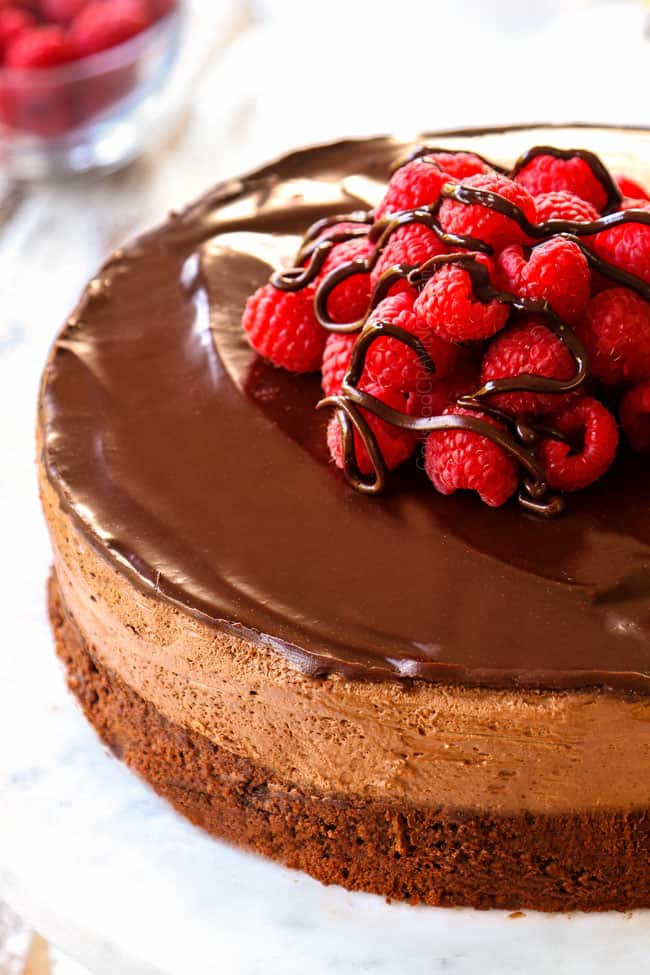 showing how to make Chocolate Mousse Cake recipe by garnishing with raspberries