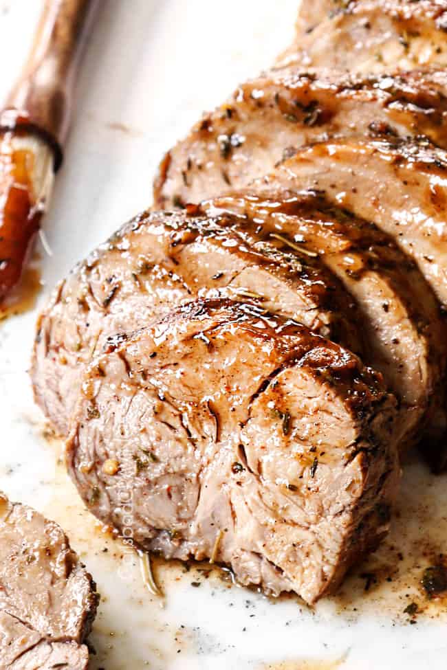 up close of crock pot pork loin sliced on a white platter