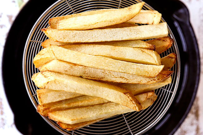 showing how to make poutine recipe by frying the potatoes until soft and lightly golden