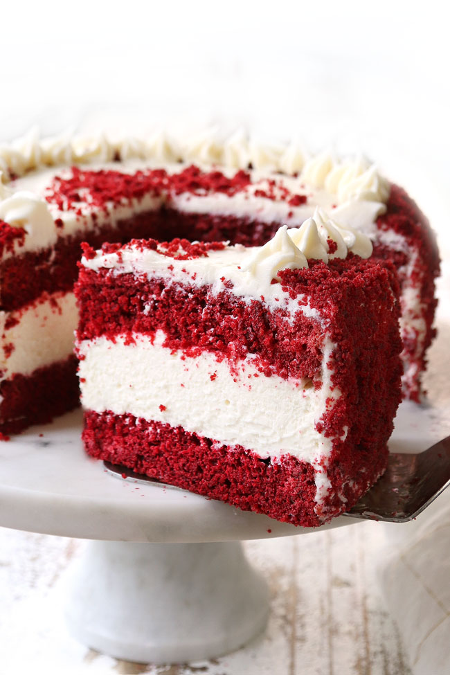 a slice of red velvet cheesecake on a cake stand